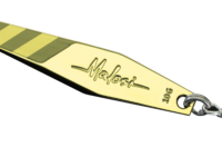 Gold fishing spoon lure with diagonal green stripes, engraved 'Malosi' and '100g', attached to a split ring and treble hooks